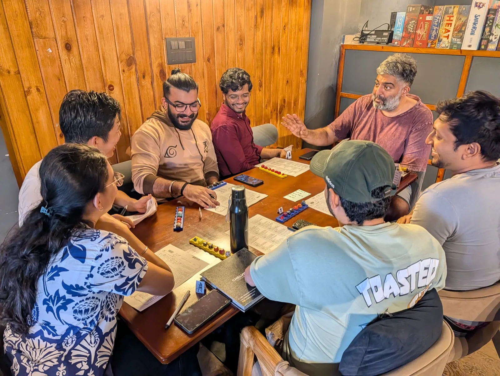 Colleagues gathered around a tabletop game in a workshop setting