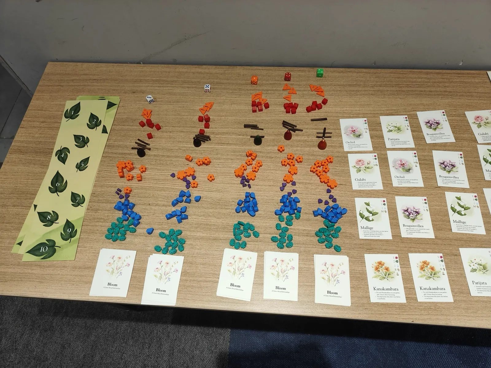 Overhead view of colorful game pieces beside illustrated cards