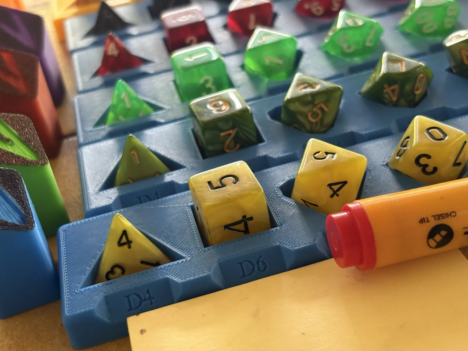 Colorful polyhedral dice arranged in a storage tray