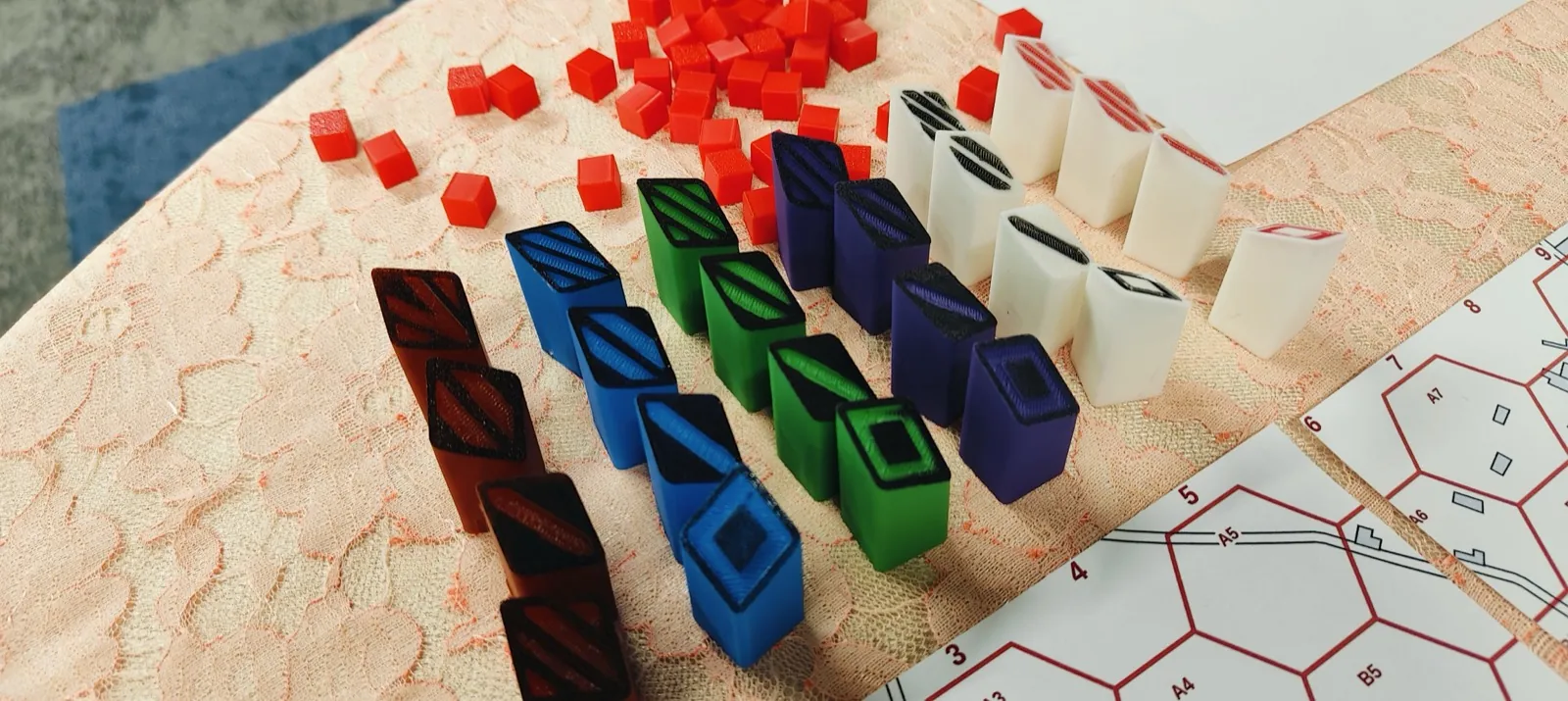 Colourful faction tokens beside a printed hex map during a serious-game workshop