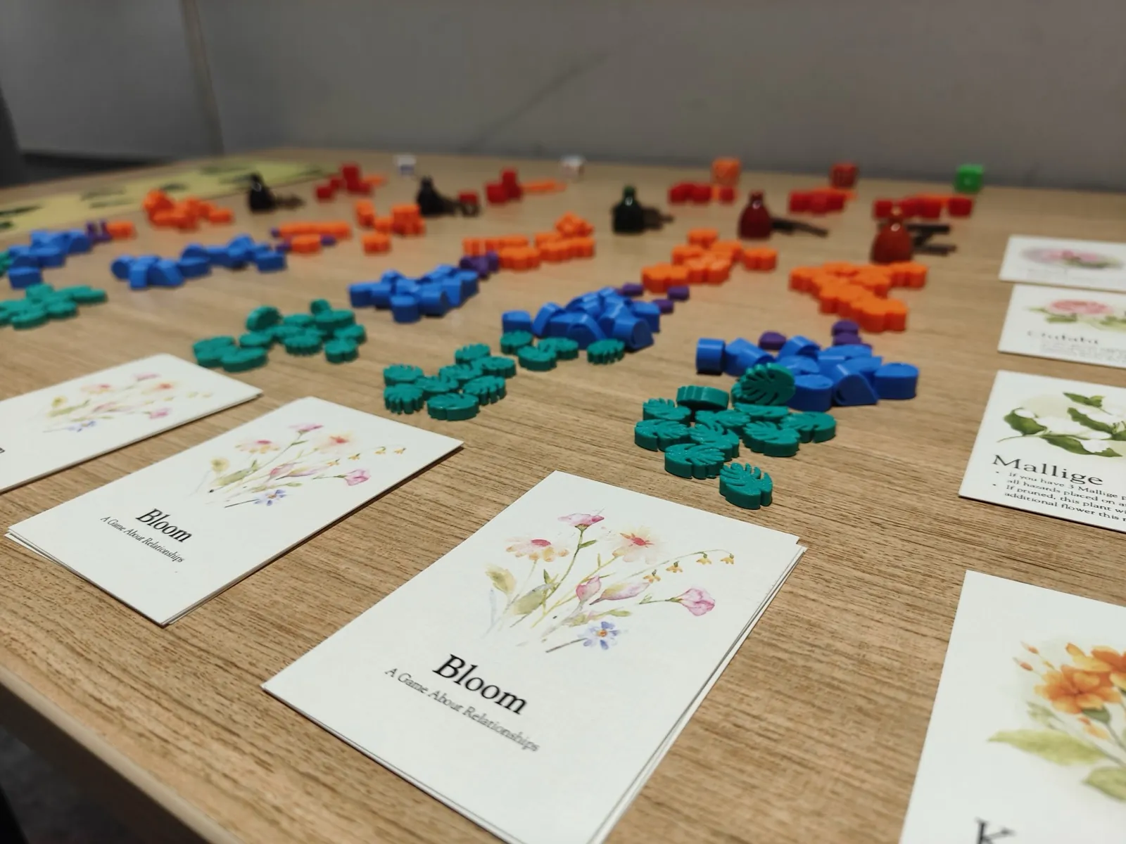 Colorful game pieces and illustrated cards arranged on a wooden table