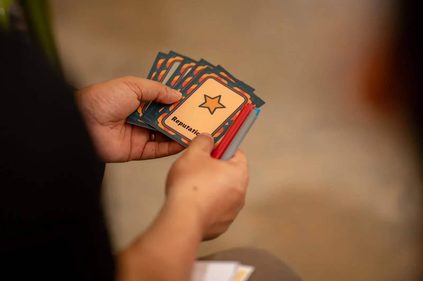 Hands holding illustrated serious-game cards
