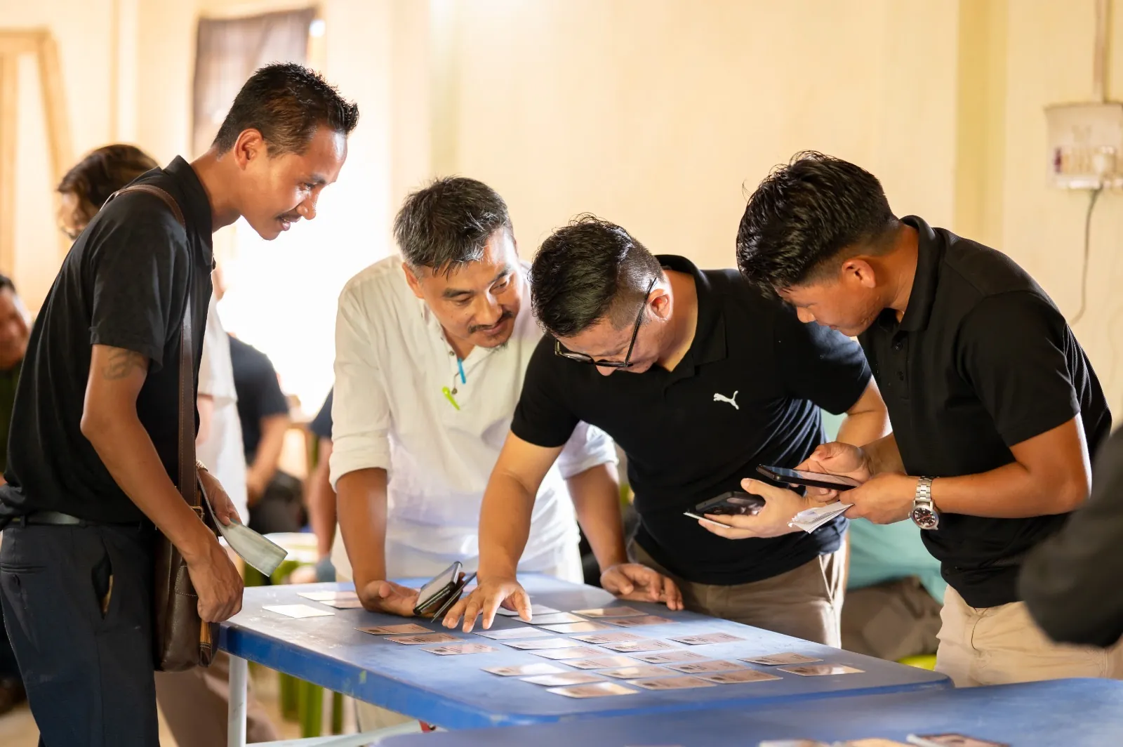 Team leaning in to a hands-on workshop activity at a table